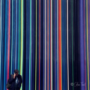 Strassenfotografie und Urbane Geometrie - Ein Mann am Telefon vor einem wand mit bunten Linien in la Defense