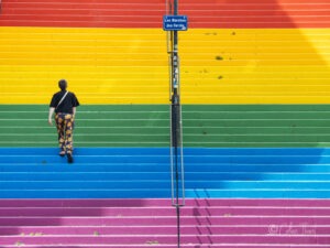 Strassenfotografie und Urbane Geometrie - ein Mann geht eine bunte Treppe hoch in Nantes