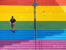 Strassenfotografie und Urbane Geometrie - ein Mann geht eine bunte Treppe hoch in Nantes