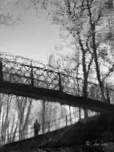 Fotoserie „Träumereien“ – Spiegelungen und Verwischungen - Spiegelung einer Mann auf einer Brücke und Bäume - schwarz weiß